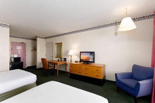 a hotel room with a bed and a desk with a television at Studio 6 Suites Lake Havasu City AZ in Lake Havasu City