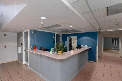 an office lobby with blue walls and a reception counter at Studio 6 Suites Lake Havasu City AZ in Lake Havasu City