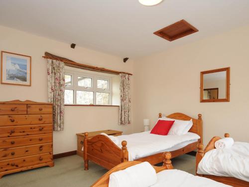 a bedroom with two beds and a window at The Granary in Saint Minver
