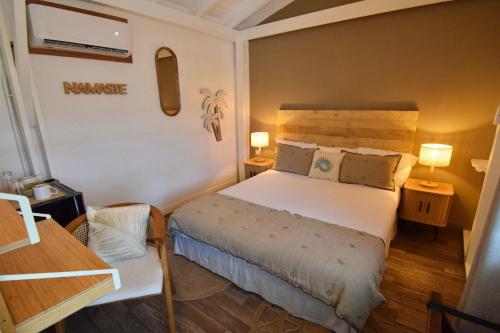 a small bedroom with a bed and two lamps at Koho SXM - ex Hevea Hotel in Grand Case