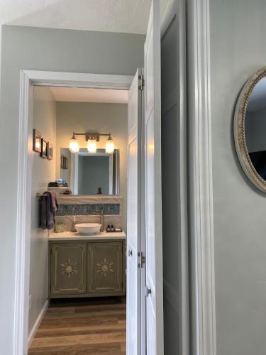 a bathroom with a sink and a mirror at Lupine Cottage - Alaska at your doorstep! in Palmer