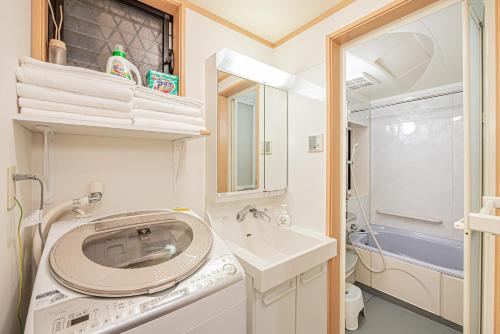 a small bathroom with a washing machine and a sink at Ikebukuro house with 5BR Free Parking in Tokyo