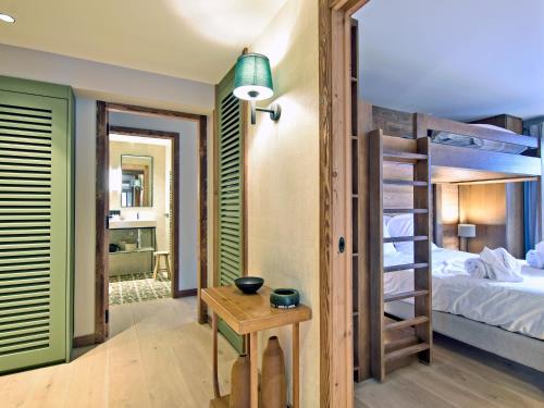 a room with a bunk bed and a room with a table at Charmant Appartement à Méribel - 3 Chambres, 6 Pers, Balcon & TV, Services Inclus - FR-1-613-33 in Méribel