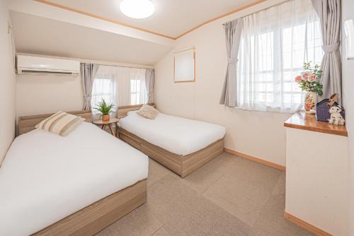 a small room with two beds and a window at Ikebukuro house with 5BR Free Parking in Tokyo