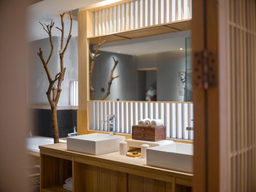 Un baño con dos lavabos y un espejo grande. en 成都鹪鹩人文精品酒店, en Chengdú