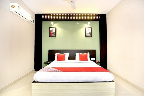 a bedroom with a large bed with red pillows at Super Hotel O Karma in Jalandhar