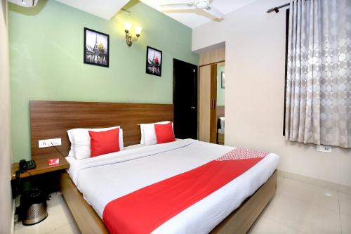 a bedroom with a large bed with red and white pillows at Super Hotel O Karma in Jalandhar