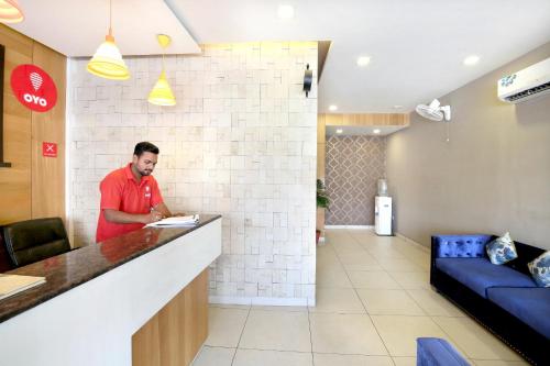a man standing at a counter in a restaurant at Super Hotel O Karma in Jalandhar