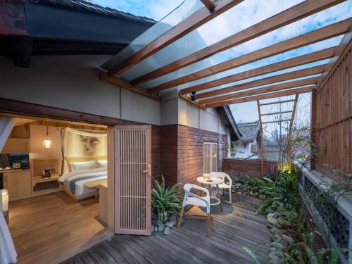 Un dormitorio principal con una cama y una terraza de madera. en 成都鹪鹩人文精品酒店, en Chengdú
