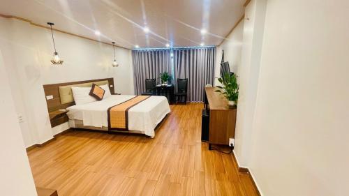a bedroom with a bed and a desk in it at HOTEL TE AMO in Hai Phong