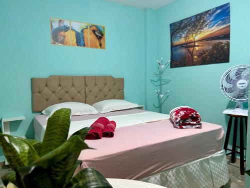a bedroom with a bed with a helmet on it at Suíte Verde in Campo Grande