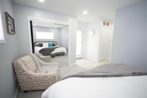 a bedroom with a bed and a mirror and a chair at Luxurious Renovated Gem in Convenient Location! in Delta