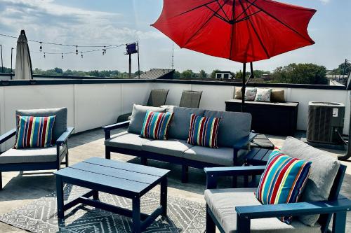 a patio with couches and a red umbrella on a roof at Spectacular Vista in Atlanta