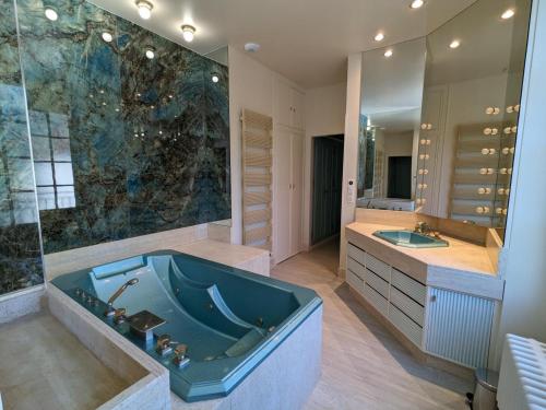 a bathroom with a large tub and a large mirror at Grande maison familiale avec piscine chauffée, wifi et parking à Pranzac - FR-1-653-284 in Pranzac