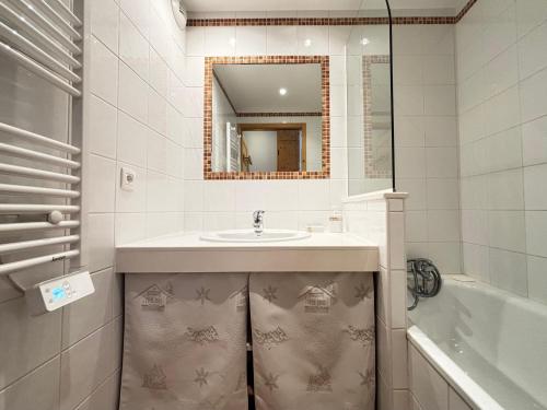 a bathroom with a sink and a mirror and a tub at Appartement avec piscine chauffée, terrasse et parking à Notre-Dame-de-Bellecombe - FR-1-505-234 in Notre-Dame-de-Bellecombe