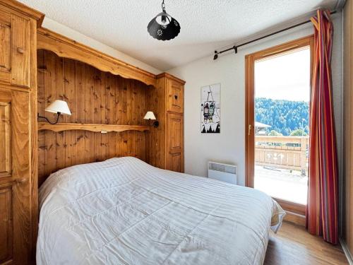 a bedroom with a large bed and a large window at Appartement avec piscine chauffée, terrasse et parking à Notre-Dame-de-Bellecombe - FR-1-505-234 in Notre-Dame-de-Bellecombe