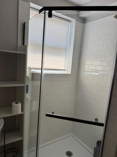 a shower with a glass door in a bathroom at Calm Retreat in Plainview
