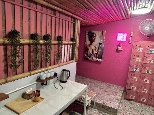 Cette chambre dispose d'une table et d'un mur violet. dans l'établissement Arena Boutique Hotel Female only, à Thongsala