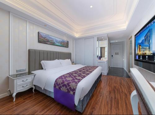 a bedroom with a large bed and a flat screen tv at Mercure Xiamen Exhibition Centre in Xiamen