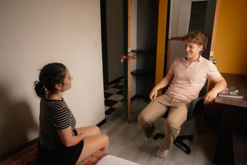 a man and a woman sitting in a room at Havana Dance School & Hostel in Cali