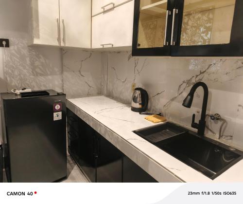 a kitchen with a sink and a black refrigerator at CBD Studio Loft 2A at City Center! in Medan