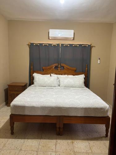 a bed with a wooden headboard in a bedroom at Double S Vacation Home in Tamasopo