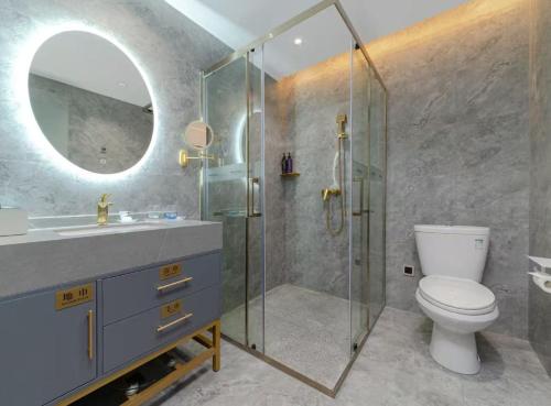 a bathroom with a toilet and a glass shower at Mercure Xiamen Exhibition Centre in Xiamen