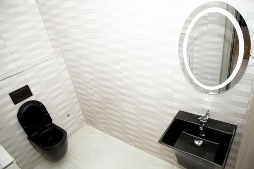 a bathroom with a black toilet and a mirror at Abuja Luxury Home in Abuja