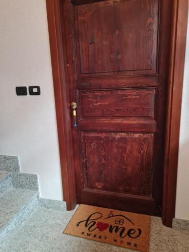 a wooden door with a welcome mat in front of it at Romantic Suite Privèe Oberje in Oulx