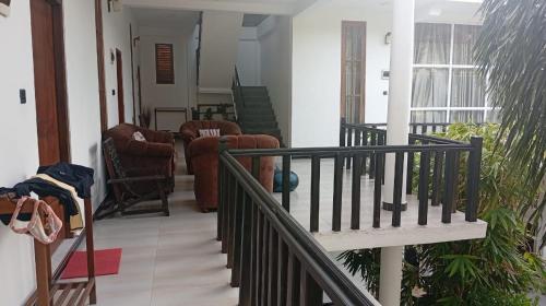 a living room with a staircase and chairs in a house at Green Ocean Bay in Arugam Bay