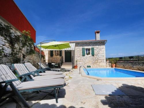 a group of lounge chairs next to a swimming pool at Villa in Tinjan with swimming pool in Tinjan