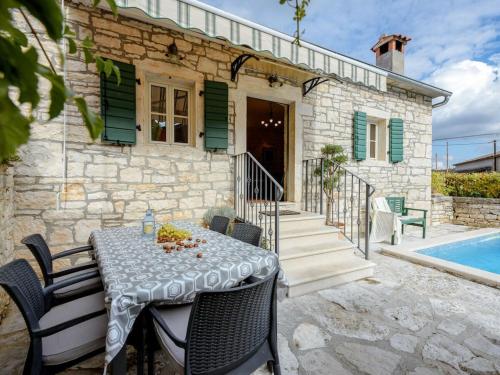 a stone house with a table and chairs and a pool at Villa in Tinjan with swimming pool in Tinjan