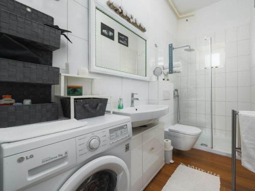 a white bathroom with a washing machine and a sink at Apartment Nina in Porec, Istria in Poreč