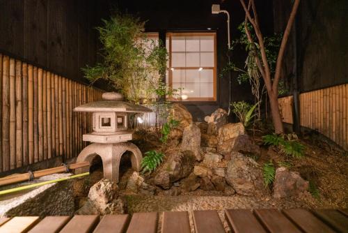 a japanese garden with a stone lantern and rocks at Shirakabanoyado - MUTSUKI, Japanese House with Garden & 3 Bathrooms, 白樺の宿 睦月 in Osaka