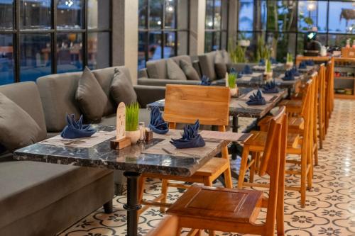 a row of tables and chairs in a restaurant at Swarga Suites Bali Berawa, Marclan Collection in Canggu