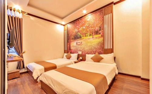 two beds in a room with a painting on the wall at S79 Residences Khai Ngoc Dalat in Da Lat