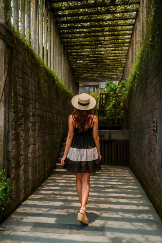 a woman in a hat walking down a tunnel at Swarga Suites Bali Berawa, Marclan Collection in Canggu