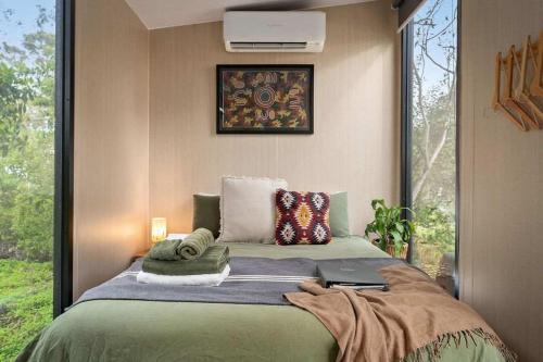 a bedroom with a bed with a laptop on it at Creekside at Peasant Farm by Tiny Away in Willunga