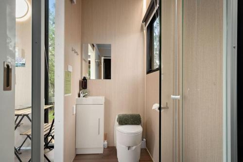 a small bathroom with a toilet and a window at Creekside at Peasant Farm by Tiny Away in Willunga