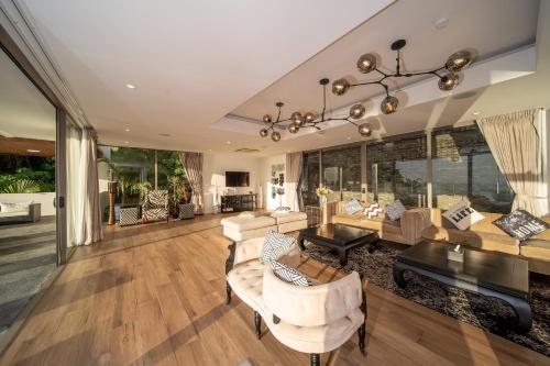 a living room filled with furniture and a large window at Seascape 6BR Prestige Villa Skyline Pool in Kamala Beach