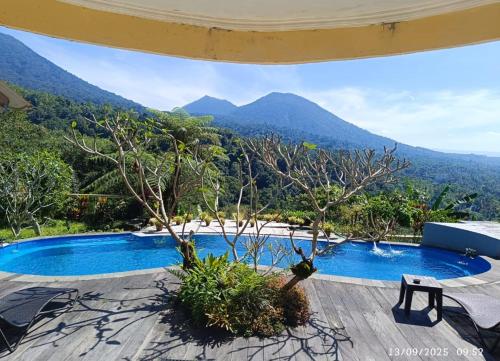 a view of a swimming pool with mountains in the background at DWan Tea Mountain Side in Jatiluwih