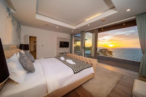 una camera da letto con un letto grande con vista sull'oceano di Seascape 6BR Prestige Villa Skyline Pool a Ban Nakhale