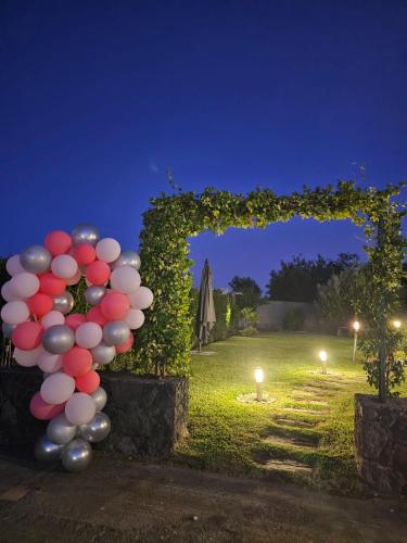 a bunch of balloons are tied to an arch with lights at Beautiful Etna's view in San Giovanni la Punta
