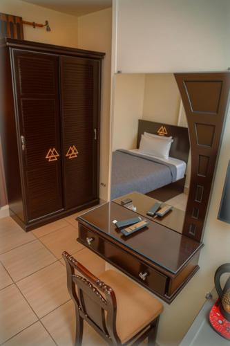 a bedroom with a bed and a desk and a mirror at Pyramids Sphinx VIEW Hotel in Cairo