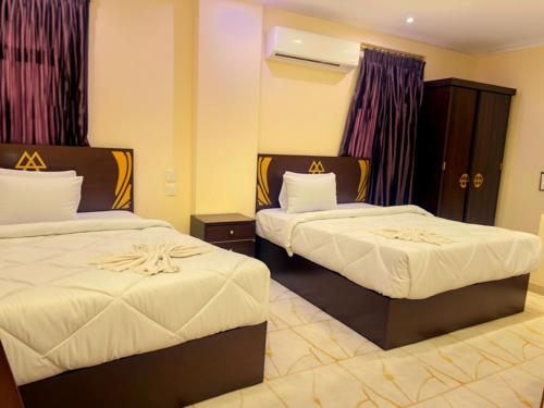 a hotel room with two beds with white sheets at Pyramids Sphinx VIEW Hotel in Cairo