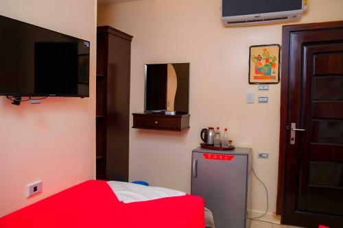 a room with a small refrigerator and a flat screen tv at Pyramids Sphinx VIEW Hotel in Cairo