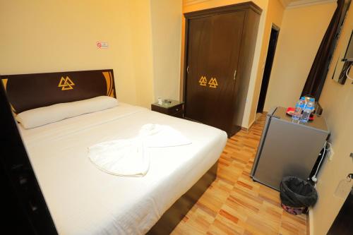 a bedroom with a bed with a white shirt on it at Pyramids Sphinx VIEW Hotel in Cairo