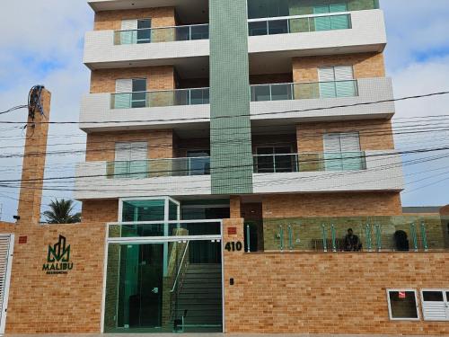 a tall brick building with a glass door at Apartamento no centro com vista para o mar in Itanhaém