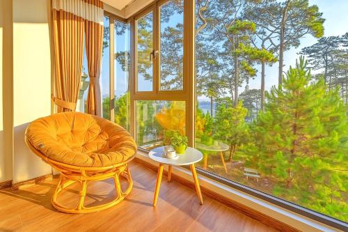 a living room with a chair and a large window at S79 Khai Ngoc Hotel Dalat in Da Lat