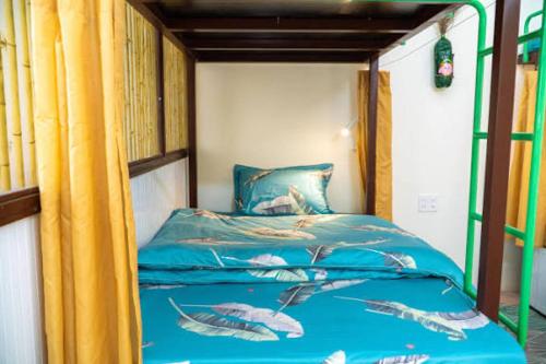 a bedroom with a bunk bed with blue sheets at Pao's Leisure Homestay in Ha Giang
